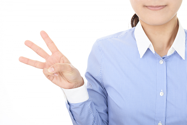指を三本立てる女性