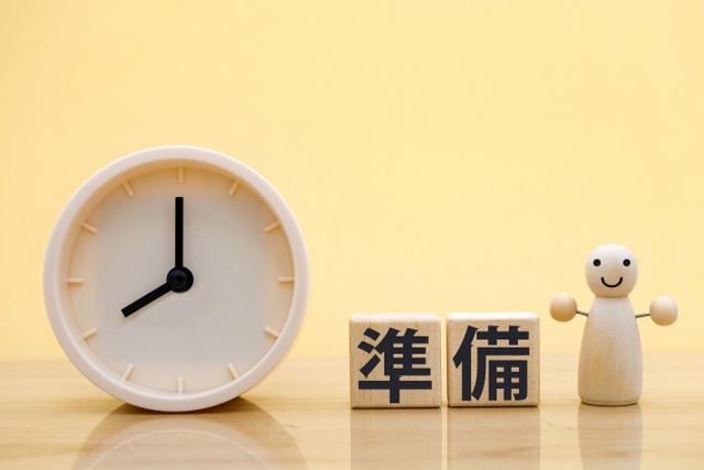 黄色の背景に時計と準備と書かれたブロックと人形