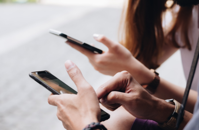 スマホをもつ2人のユーザーの手元