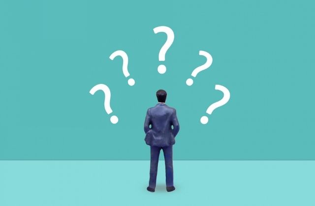 疑問符を浮かべるミニチュア男性