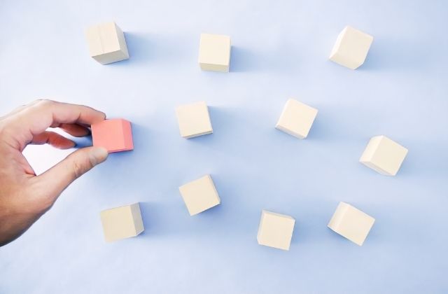 多くのブロックの中から1つを掴み取る手