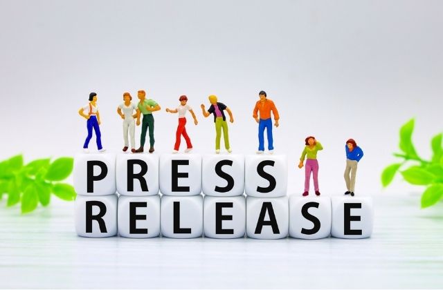 プレスリリースの文字とミニチュアの人々