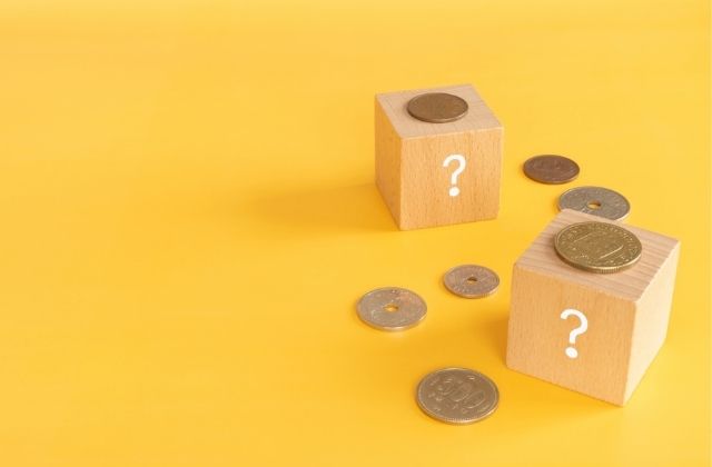 疑問符が書かれたブロックとコイン
