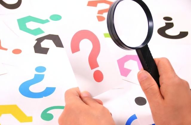 疑問符が描かれたカードと虫眼鏡