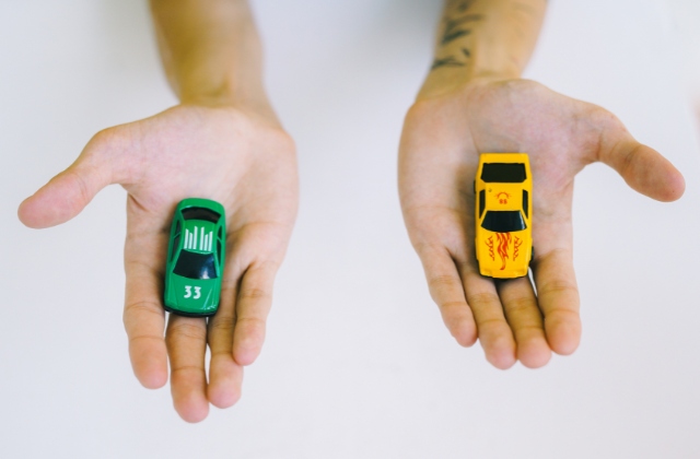 二種類のミニカーを持っている画像