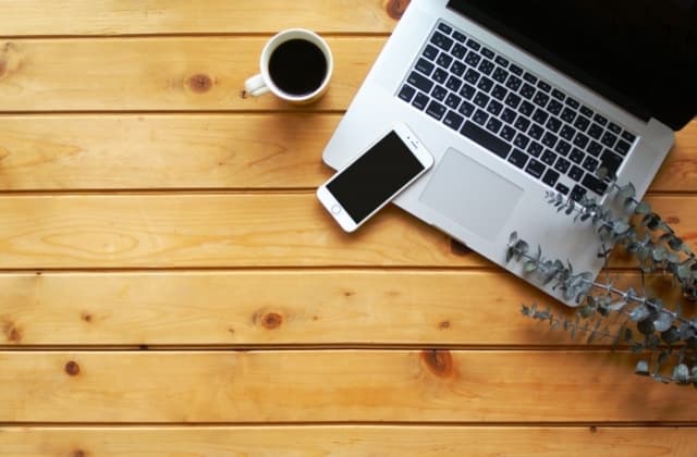 デスクの上にパソコンとコーヒー