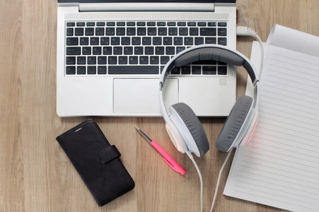 机の上にパソコンとヘッドホン