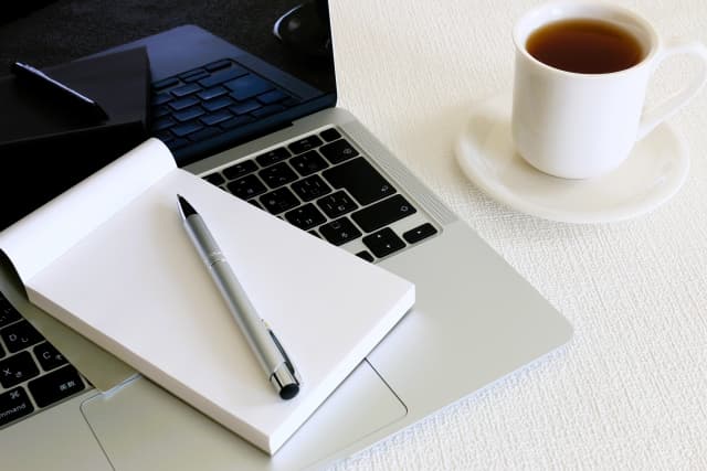 机の上にパソコンとコーヒー