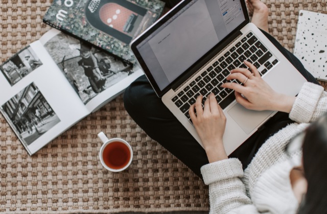 膝の上でパソコンをいじっている写真