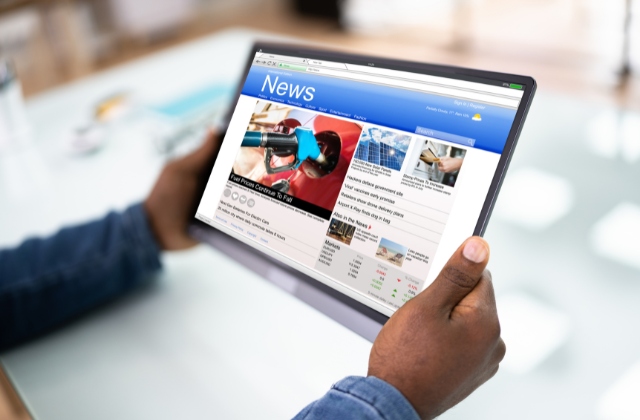 タブレットを両手で持って記事を読んでいる画像