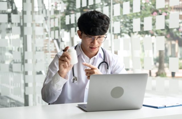 ノートパソコンの前で物を説明している画像