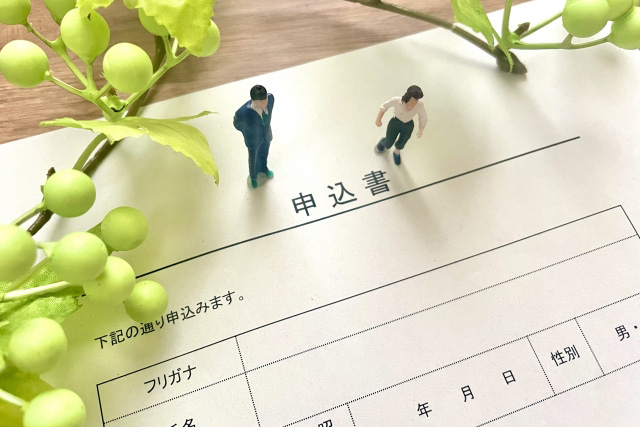 申込書の上に立つミニチュア